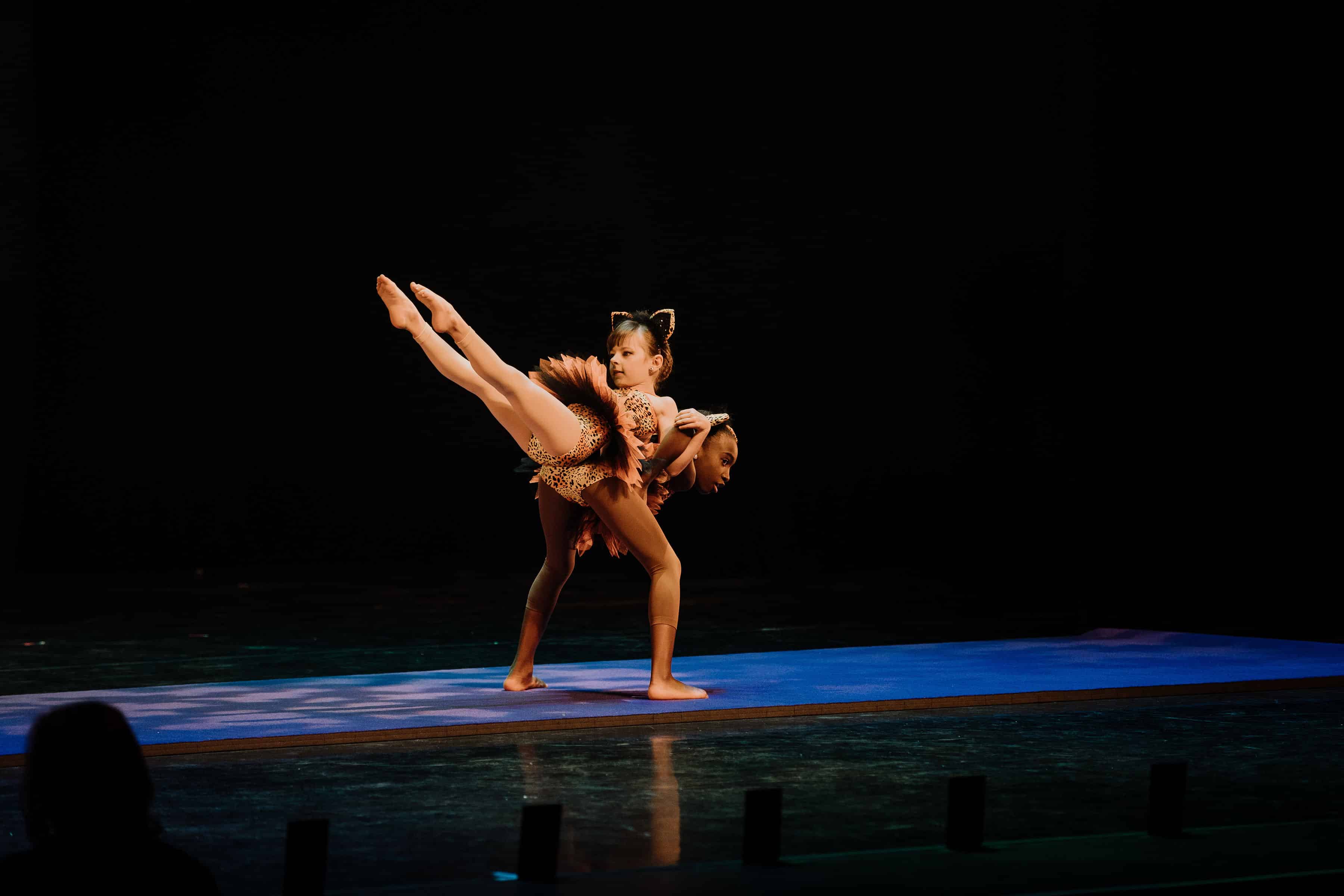 Two dancers performing an Acro routine on stage