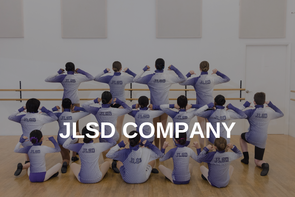 Group shot of company dancers pointing at the back of their jackets with JLSD Company written over top