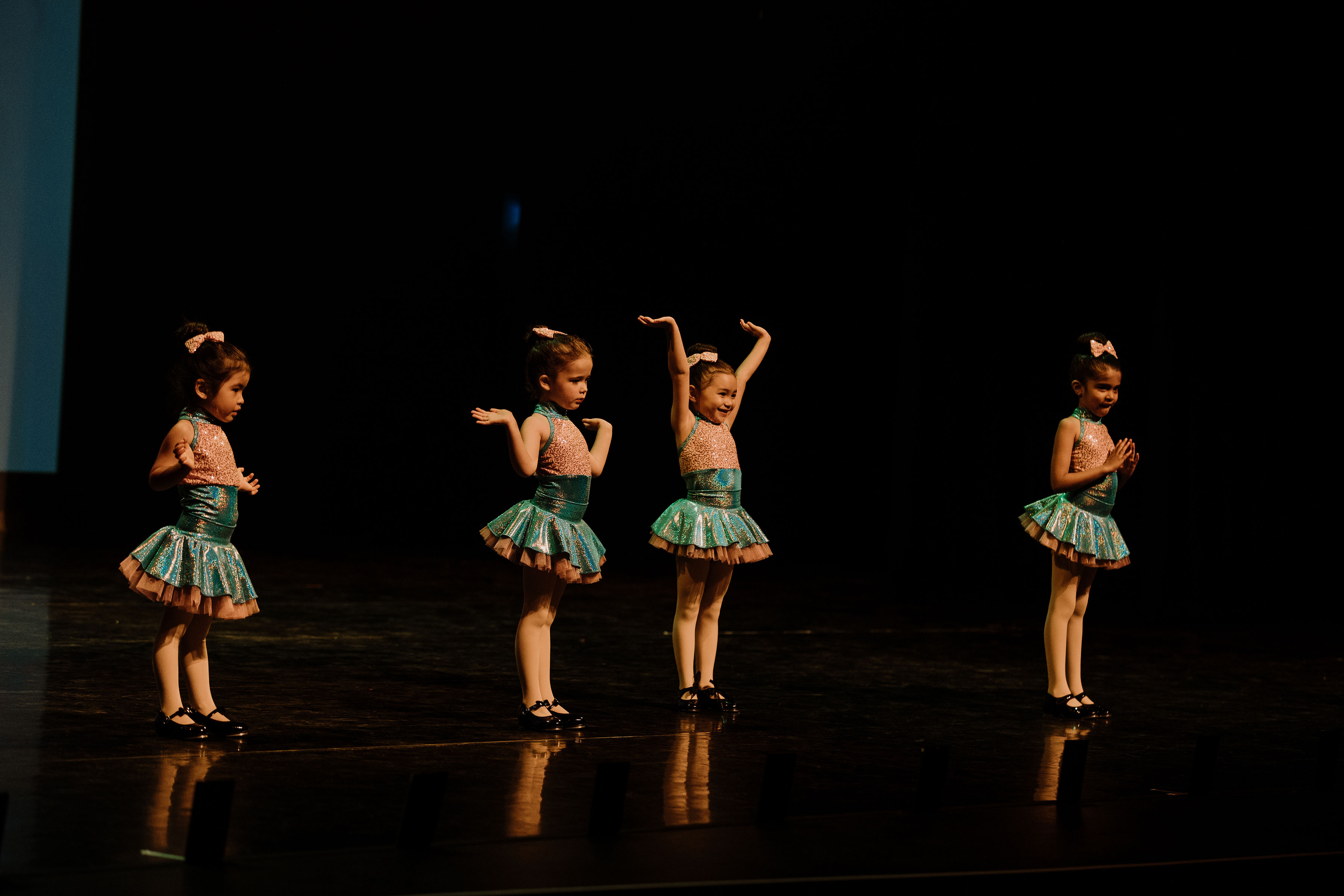 Four dancers performing tap dance on stage