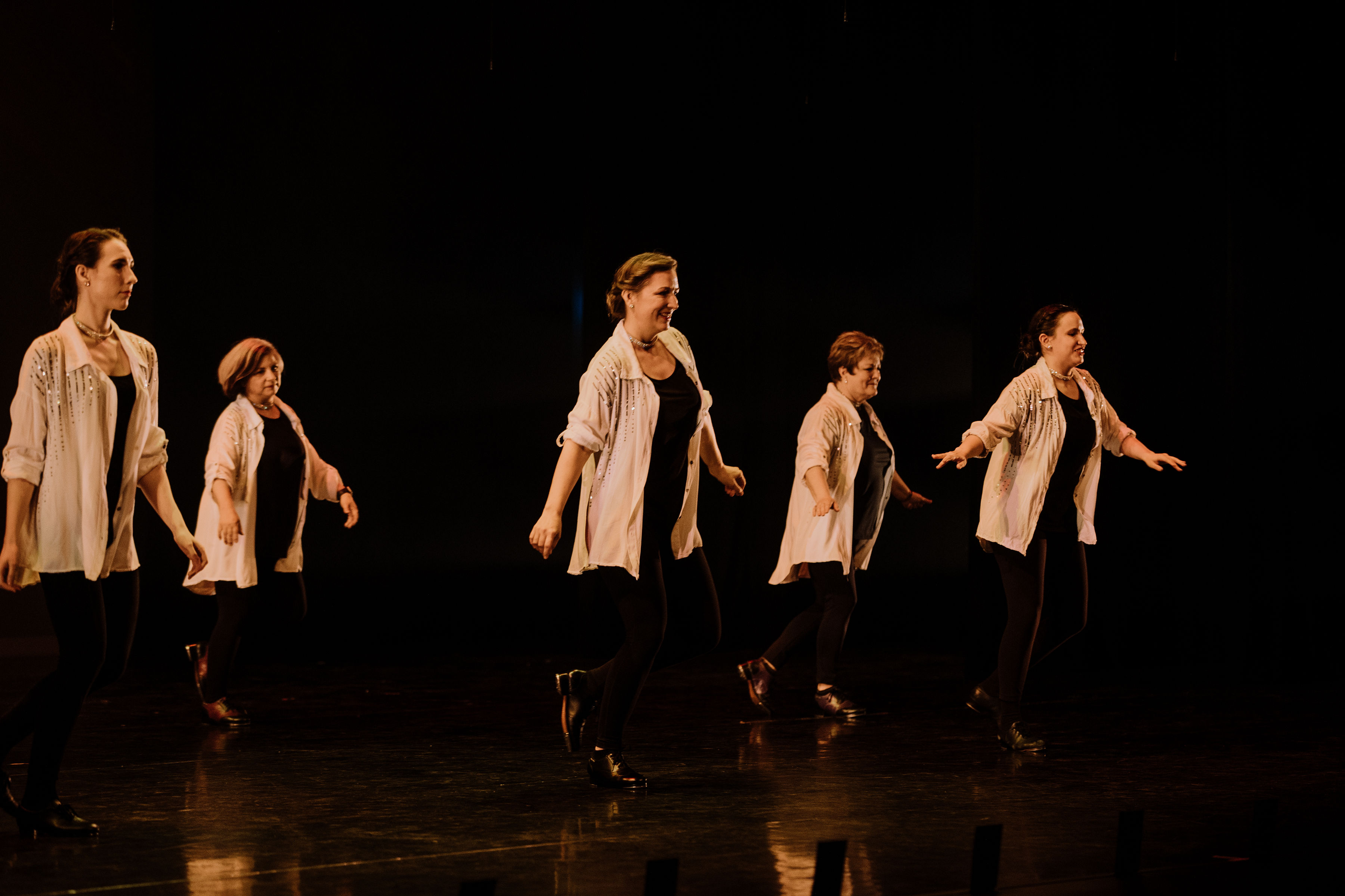 Adult tap dancers performing on stage