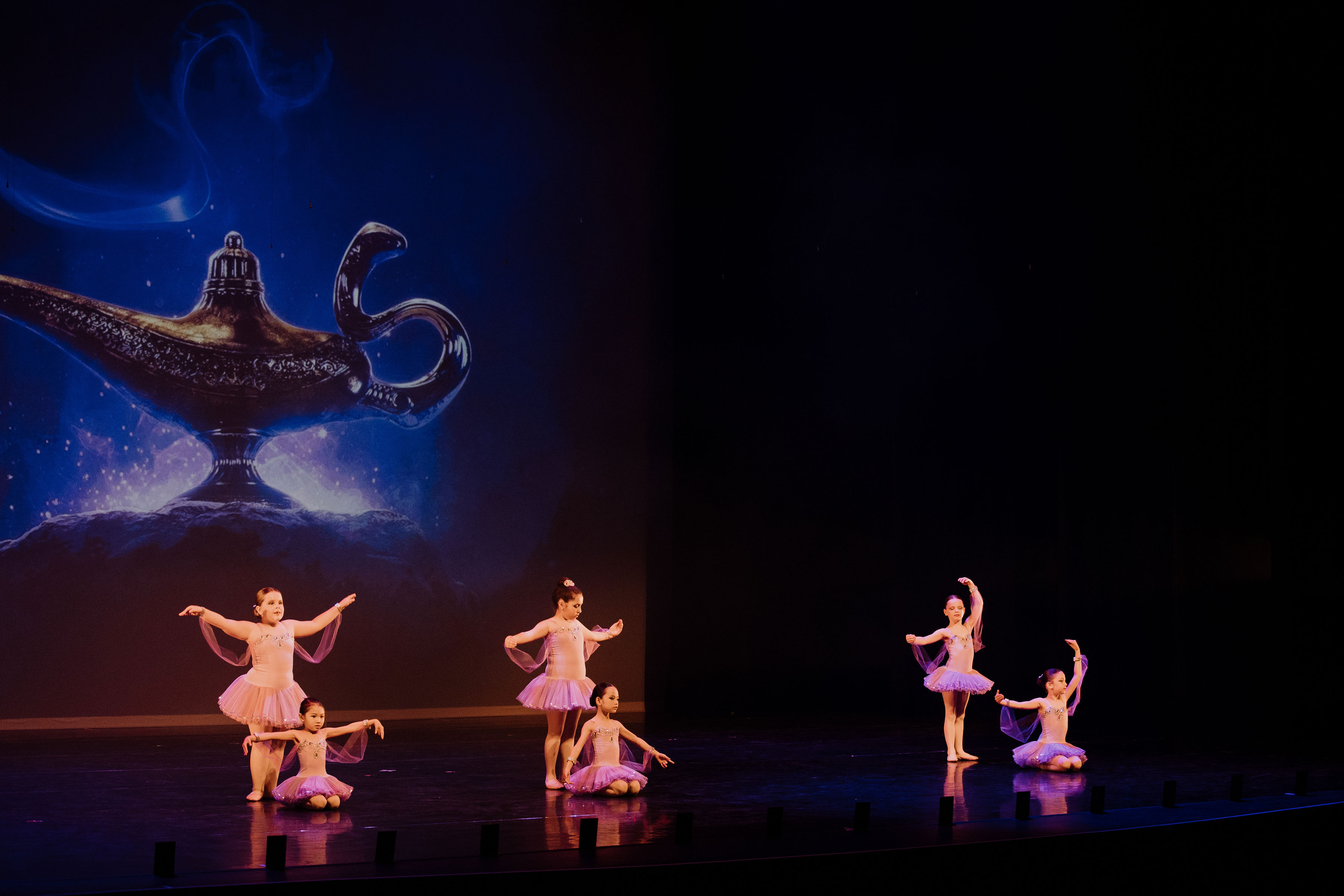 Six dancers performing ballet routine on stage