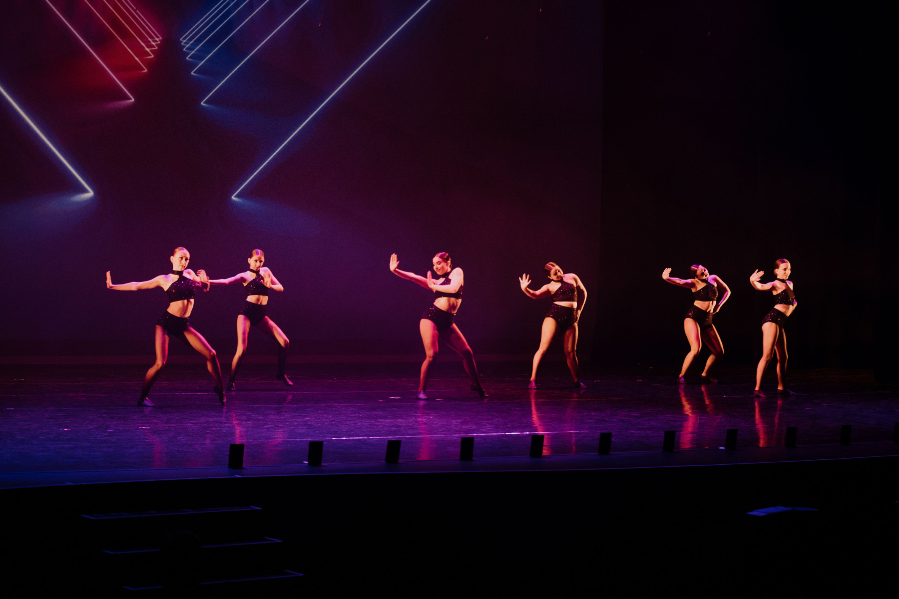 Six dancers performing a jazz routine